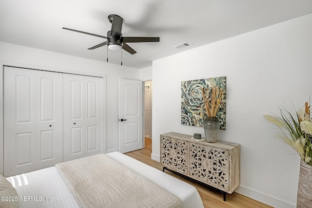 bedroom with ceiling fan, light wood-type flooring, and a closet