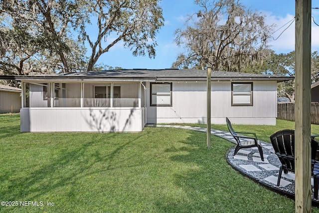 back of house featuring a yard and a sunroom