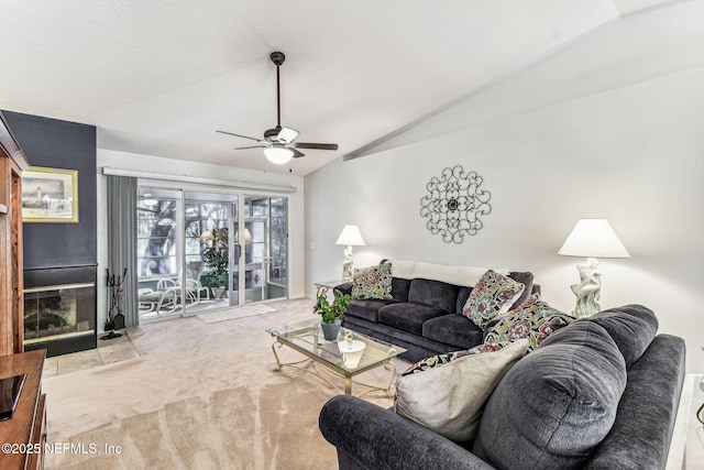 carpeted living room with ceiling fan and vaulted ceiling