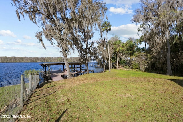 dock area featuring a lawn and a water view