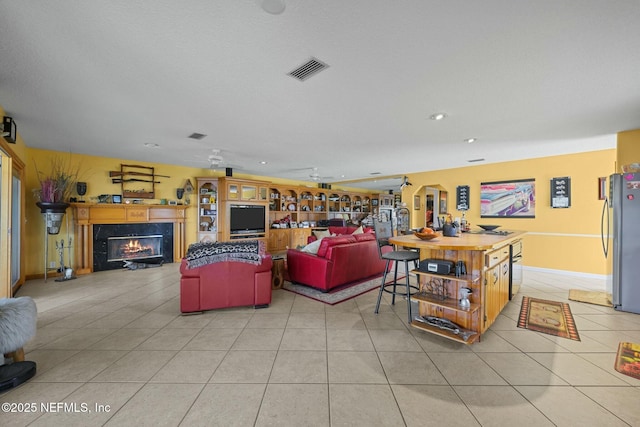 living room with light tile patterned floors and a fireplace