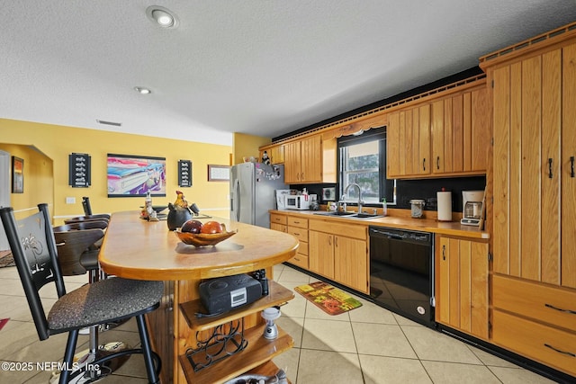 kitchen with light tile patterned flooring, sink, stainless steel fridge with ice dispenser, a textured ceiling, and dishwasher