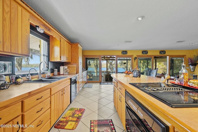 kitchen with sink, light tile patterned floors, a textured ceiling, and black appliances