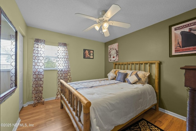 bedroom featuring ceiling fan, a textured ceiling, and light hardwood / wood-style flooring