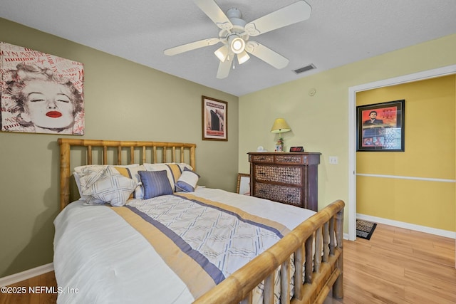 bedroom featuring a textured ceiling, ceiling fan, and light wood-type flooring