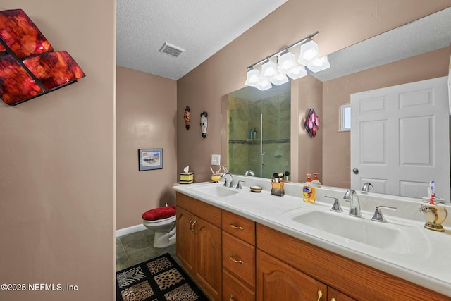 bathroom with tile patterned flooring, an enclosed shower, vanity, a textured ceiling, and toilet