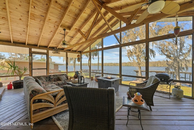 sunroom with plenty of natural light, vaulted ceiling with beams, ceiling fan, a water view, and wooden ceiling