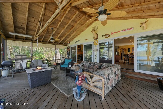 sunroom / solarium with ceiling fan, vaulted ceiling with beams, and wood ceiling