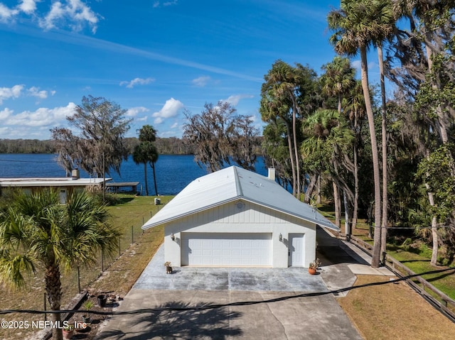 exterior space with a garage, a water view, and a front lawn