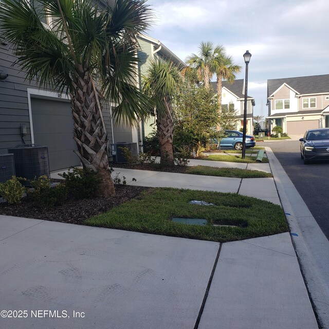 11107 Quasar Ct, Jacksonville, FL 32256 - view of yard featuring a garage, a residential view, and central AC unit