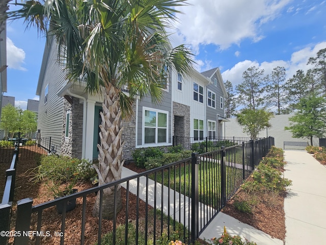 11107 Quasar Ct, Jacksonville, FL 32256 - view of property exterior featuring a garage, stone siding, board and batten siding, and fence private yard
