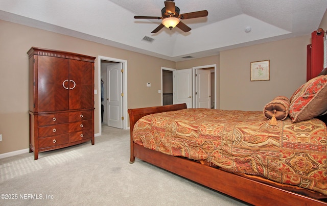 carpeted bedroom featuring ceiling fan and a raised ceiling