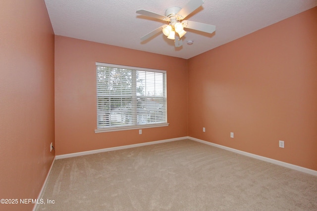 carpeted spare room with a textured ceiling and ceiling fan