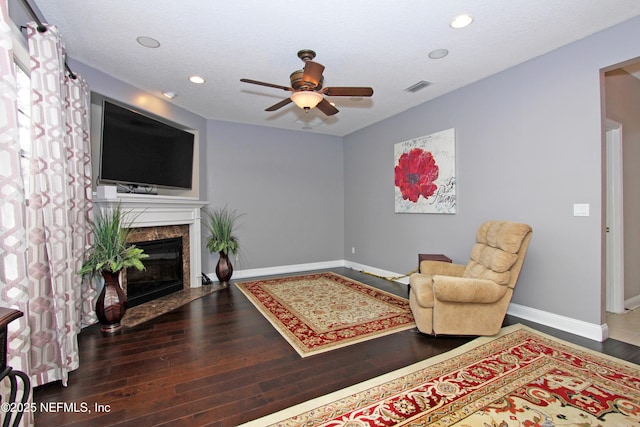 interior space with hardwood / wood-style flooring, ceiling fan, a textured ceiling, and a high end fireplace