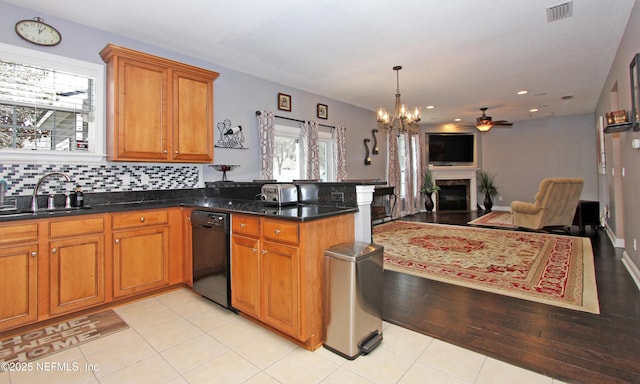 kitchen with dishwasher, sink, decorative backsplash, hanging light fixtures, and kitchen peninsula