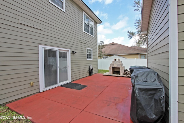 view of patio / terrace featuring grilling area and an outdoor stone fireplace