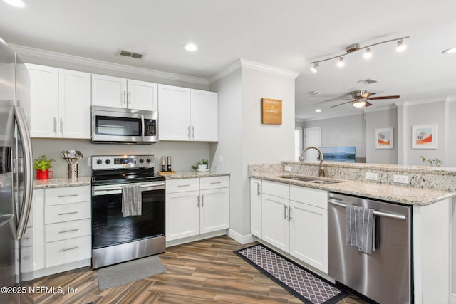 kitchen with crown molding, stainless steel appliances, sink, and white cabinets