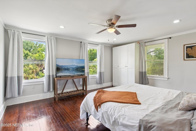 bedroom featuring multiple windows, crown molding, ceiling fan, and dark hardwood / wood-style flooring