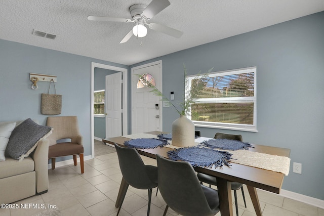 dining room with ceiling fan, light tile patterned floors, and a textured ceiling