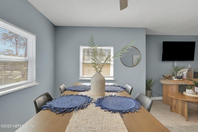 dining space featuring light tile patterned flooring and a textured ceiling