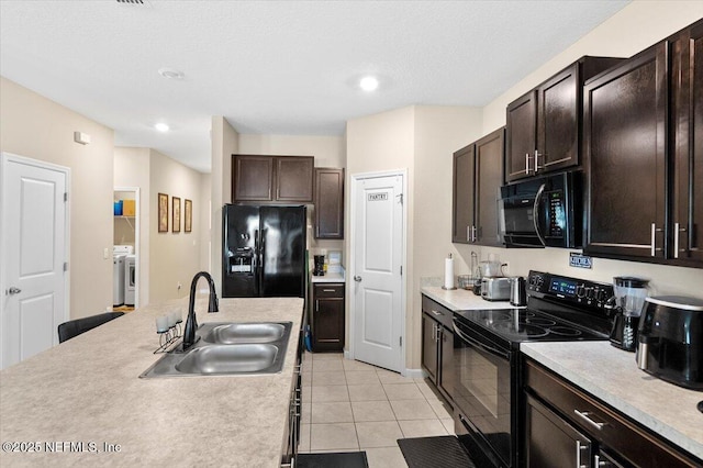 kitchen featuring light tile patterned floors, dark brown cabinetry, sink, and black appliances