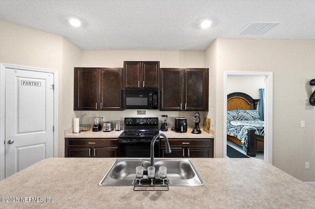 kitchen with sink, dark brown cabinetry, and black appliances