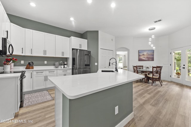 kitchen featuring stainless steel appliances, an island with sink, sink, and white cabinets