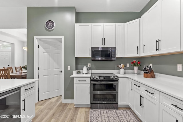 kitchen with appliances with stainless steel finishes, wine cooler, white cabinets, and light wood-type flooring