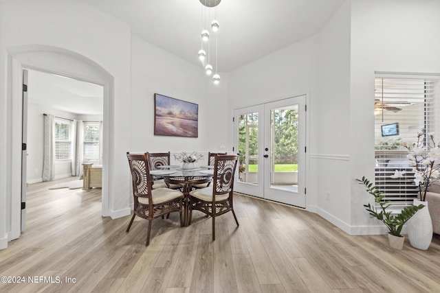 dining room featuring french doors, a high ceiling, and light wood-type flooring