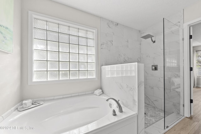 bathroom featuring plus walk in shower and a textured ceiling