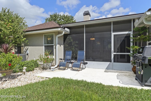 rear view of property with a patio area and a sunroom