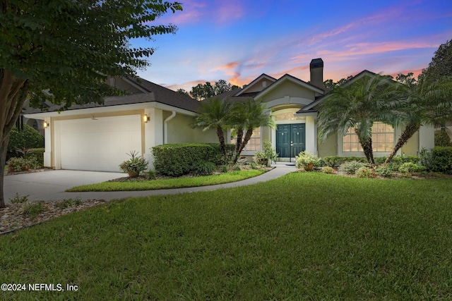 view of front facade with a garage and a lawn