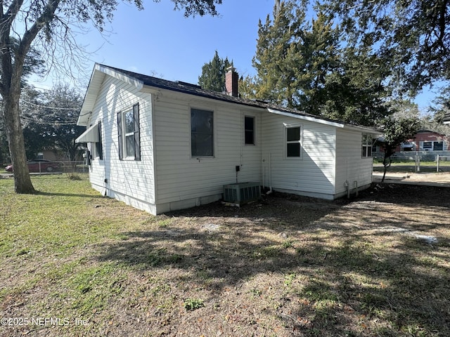 rear view of property with a yard and central AC unit