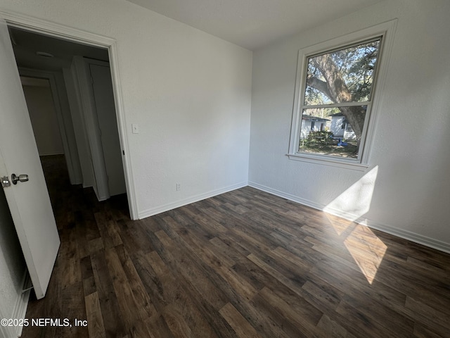 spare room with dark wood-type flooring