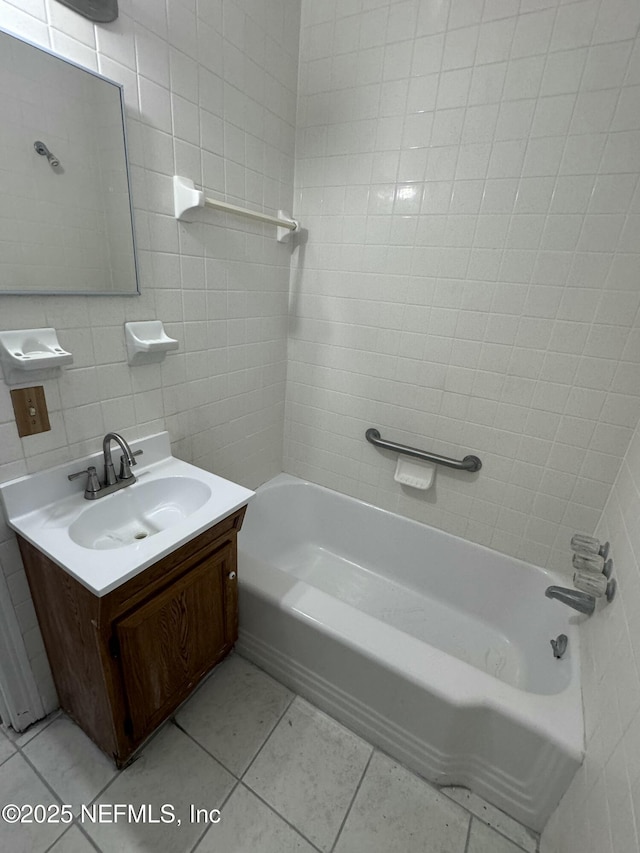 bathroom featuring vanity, tile walls, tile patterned floors, and tiled shower / bath