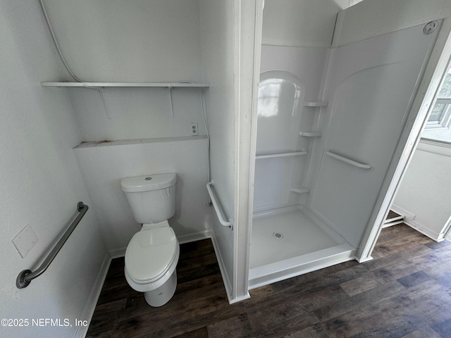 bathroom with wood-type flooring, a shower, and toilet