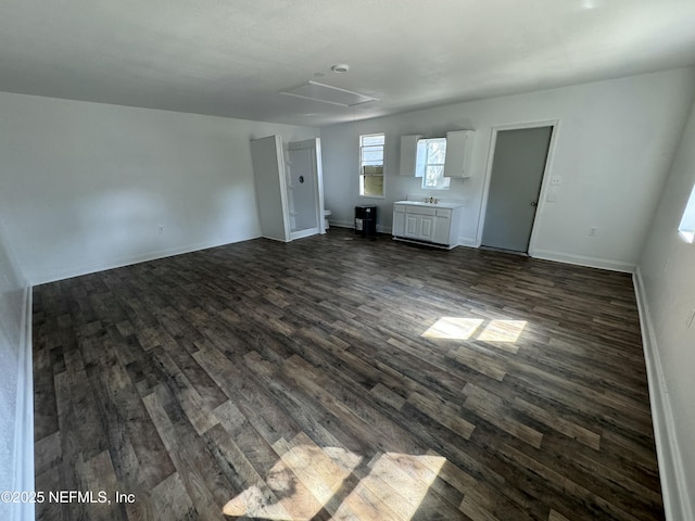 unfurnished living room featuring sink and dark wood-type flooring