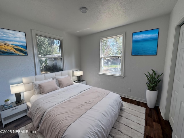 bedroom with dark hardwood / wood-style flooring and a textured ceiling