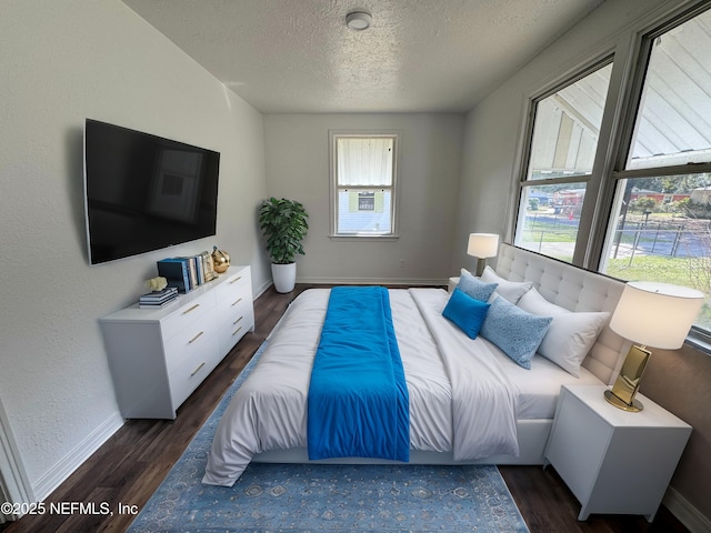 bedroom featuring a textured ceiling and dark hardwood / wood-style flooring