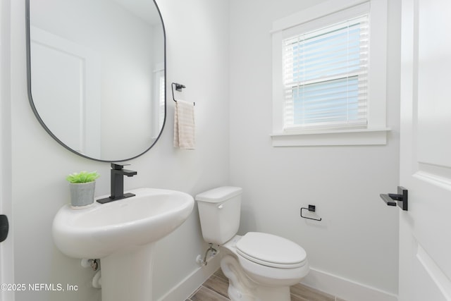 bathroom with hardwood / wood-style flooring and toilet