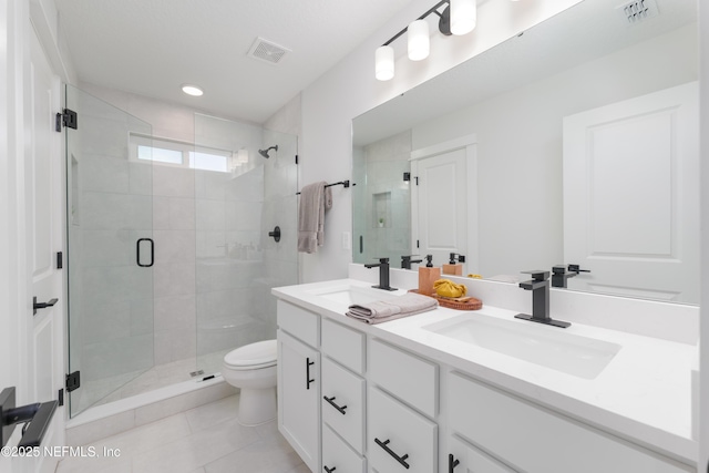 bathroom featuring vanity, a shower with shower door, tile patterned floors, and toilet