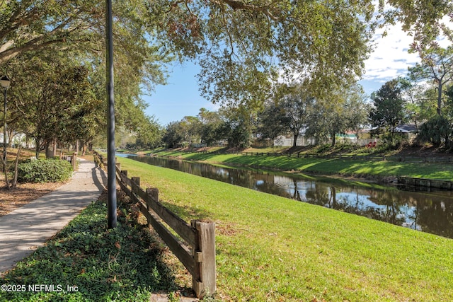 view of home's community with a yard and a water view