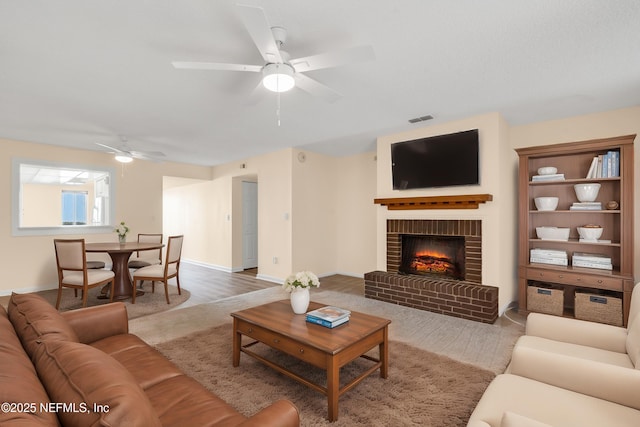 living room featuring ceiling fan and a brick fireplace