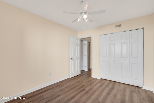 unfurnished bedroom with hardwood / wood-style flooring, a closet, and ceiling fan