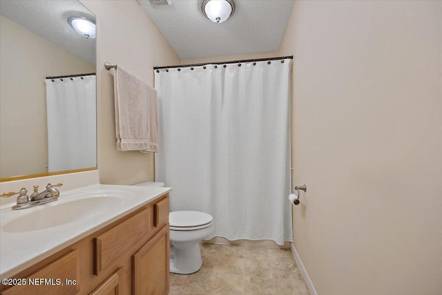 bathroom featuring vanity, a textured ceiling, and toilet