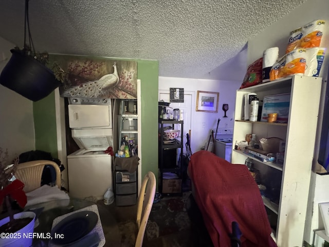 kitchen with stacked washer / dryer and a textured ceiling