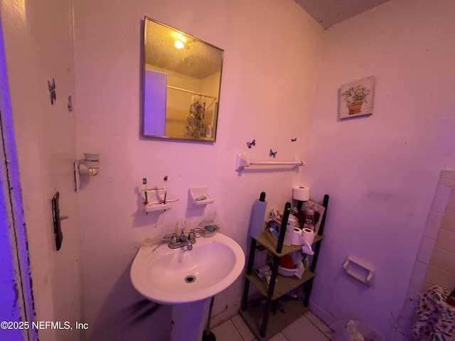 bathroom with sink, curtained shower, and tile patterned floors