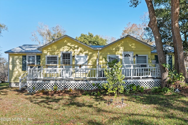 view of front of property with a deck and a front lawn