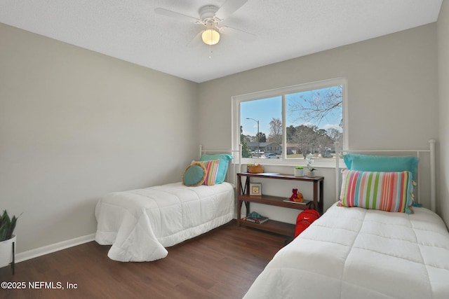 bedroom featuring ceiling fan, dark hardwood / wood-style floors, and a textured ceiling