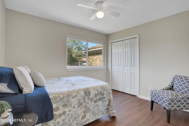 bedroom featuring ceiling fan, dark hardwood / wood-style floors, a closet, and a textured ceiling